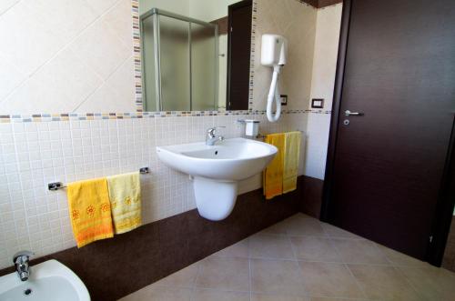 y baño con lavabo, espejo y aseo. en B&B La Porta Accanto, en Sassari