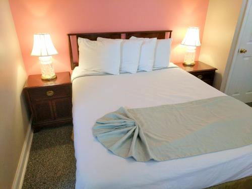 
a bed with a white comforter and pillows at Key West Hotel in Wildwood

