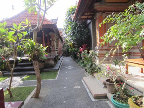 a walkway in front of a house with trees and plants at Danasari Homestay in Ubud