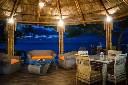 a patio with a table and chairs and a view of the ocean at Hotel Vistalmar in Manta