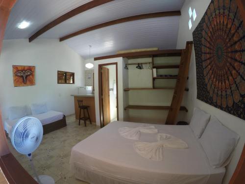 een slaapkamer met een bed, een ventilator en een trap bij Little Kamala in Pipa