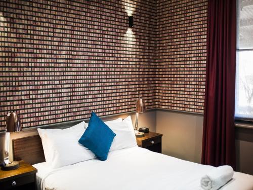 a bedroom with a bed with a blue pillow at Criterion Hotel Sale in Sale
