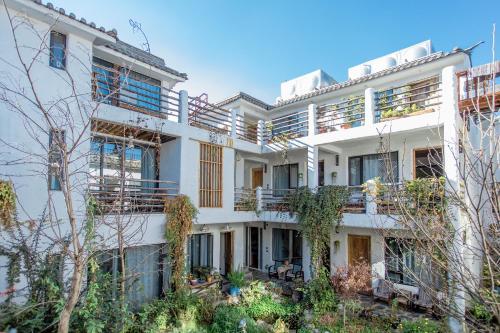 un edificio de apartamentos con balcones y plantas en Hidden Hotel, en Dali