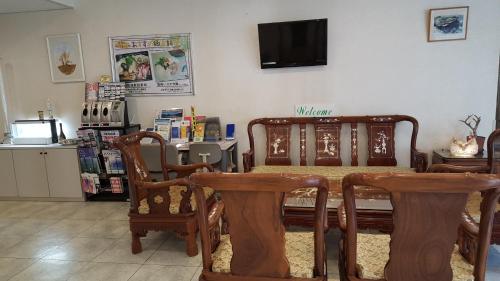 a room with a table and chairs and a tv at Hotel Belleforet in Tsushima