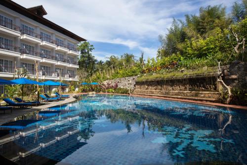 a large swimming pool in front of a building at Plataran Heritage Borobudur Hotel in Borobudur