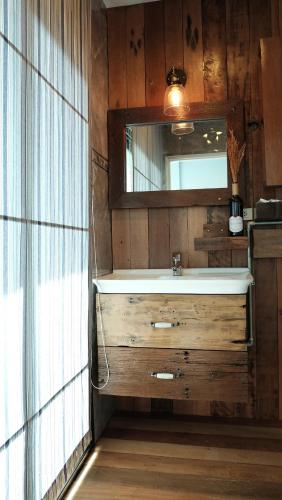 a bathroom with a sink and a mirror at The Brown House Hotel in Chachoengsao
