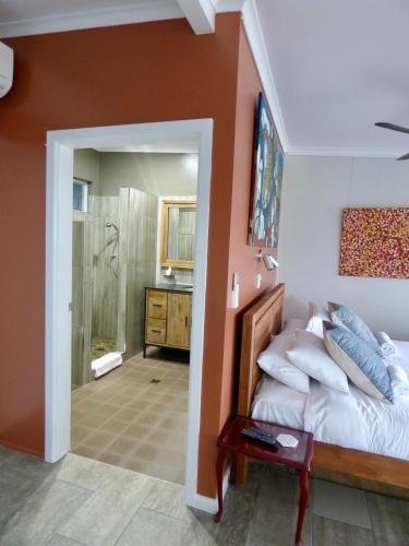 a bedroom with a bed and a bathroom with a shower at ArtHOUSE Beachfront Accommodation in Emerald Beach