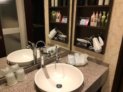 a bathroom counter with a sink and a mirror at AURA Resort Iga (Adult Only) in Iga