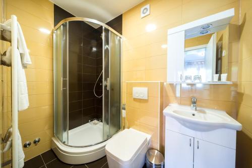 a bathroom with a shower and a sink and a toilet at Villa Gradski Vrt in Osijek