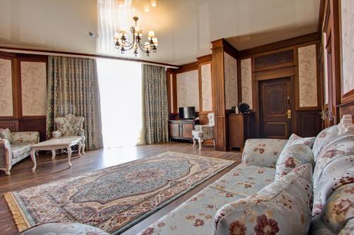 a living room with a couch and a rug at Karagat Hotel in Karakol
