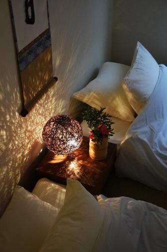 a bedroom with two beds and a table with a lamp at Guesthouse Chayama in Kyoto