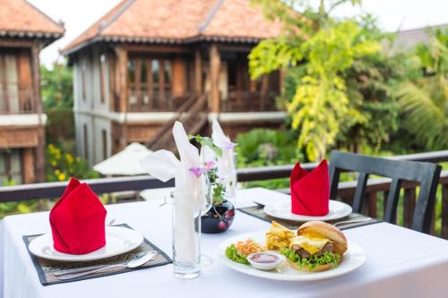 a table with two plates of food and red napkins at Khmer Paradise Villa in Siem Reap