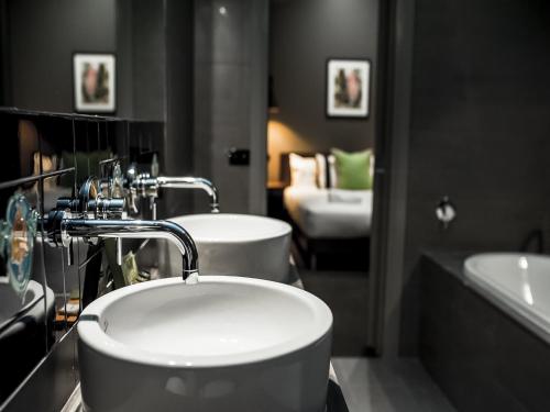 a bathroom with two sinks and a tub at Criterion Hotel Sale in Sale