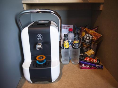 a drink dispenser sitting on a counter with snacks at Criterion Hotel Sale in Sale