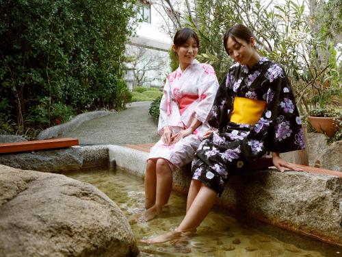 two women in kimonos sitting in a pool of water at Yumoto Konpira Onsen Hananoyu Kobaitei in Kotohira