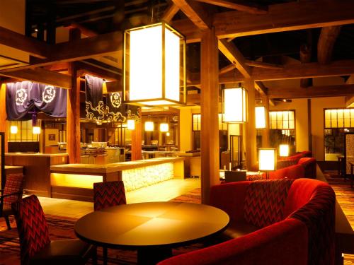 a restaurant with red chairs and a table and a bar at Yumoto Konpira Onsen Hananoyu Kobaitei in Kotohira