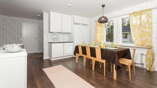 una cucina e una sala da pranzo con tavolo e sedie di Tiinan tupa A a Moksinkylä