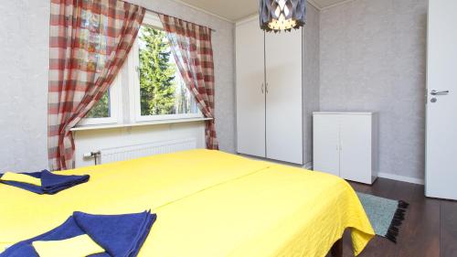 un letto giallo in una camera da letto con finestra di Tiinan tupa A a Moksinkylä