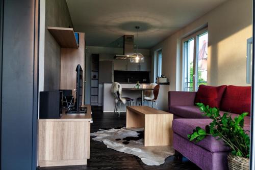 a living room with a purple couch and a kitchen at Hewen Apartments in Engen