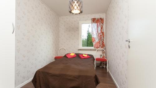 MoksinkyläにあるTiinan tupa Bの赤い枕が付いたベッドが備わる客室です。