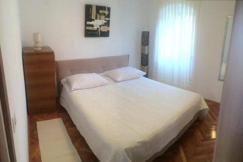 a bedroom with a white bed and a window at Augustinovi Dvori in Škrip