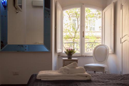 um quarto com uma cama, uma janela e uma cadeira em White Vatican em Roma