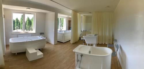 a large bathroom with two sinks and a tub and a bath tub at Hotel *** NAT Jarosławiec in Jarosławiec