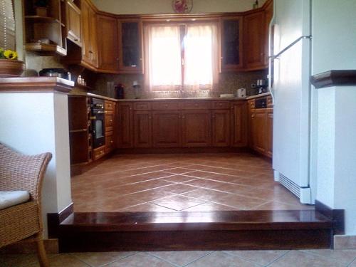 a large kitchen with wooden cabinets and a window at Villa Rose Garden in Agios Ioannis