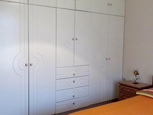 a white closet with white cabinets in a bedroom at Villa Rose Garden in Agios Ioannis