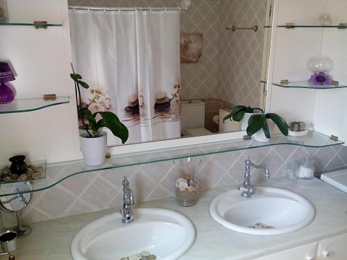 a bathroom with two sinks and a mirror at Villa Rose Garden in Agios Ioannis