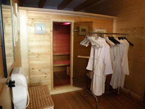 a walk in closet with white clothes on racks at Hotel Al Pelmo Wellness in Pieve di Cadore