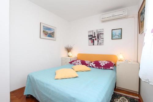 a bedroom with a blue bed with two pillows at Apartments Monpeloso in Rovinj