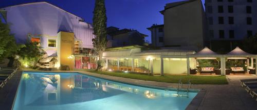 una piscina di fronte a una casa di notte di Adua & Regina di Saba Wellness & Beauty a Montecatini Terme