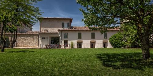 a large house with a green yard in front of it at Hotel Cortaccia Sanvitale in Sala Baganza