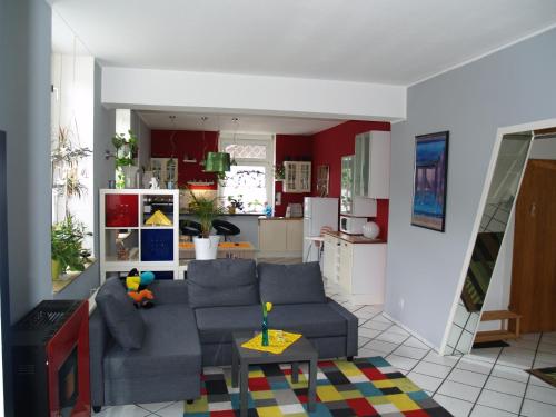 a living room with a couch and a kitchen at Ferienwohnung Eschenbeek in Wuppertal