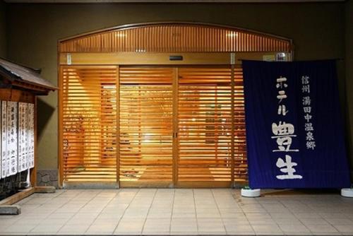 a front door of a building with a sign on it at Hotel Housei in Yamanouchi