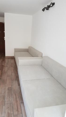 - un canapé blanc avec des verres sur un mur dans l'établissement Super studio cap d'agde, au Cap d'Agde