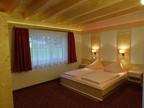 a bedroom with a bed and a window at Appartements Loisachpromenade in Ehrwald