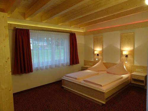 エールヴァルトにあるAppartements Loisachpromenadeのベッドルーム(ベッド1台、窓付)