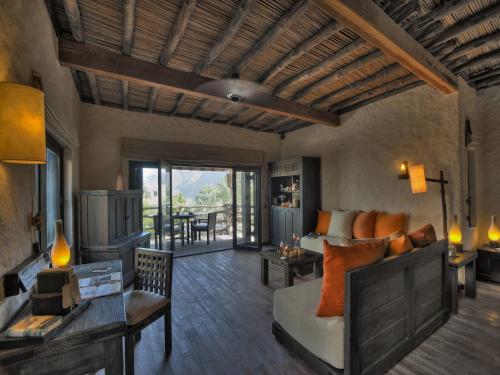a living room with a couch and a table at Six Senses Zighy Bay in Dibba
