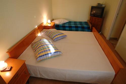 two pillows on a large bed in a room at Apartments Benito in Pješčana Uvala 