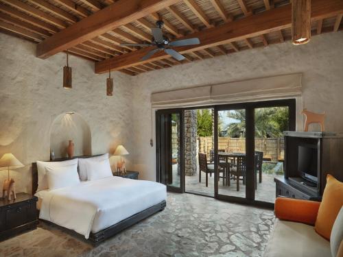 a bedroom in a villa with a bed and a tv at Six Senses Zighy Bay in Dibba
