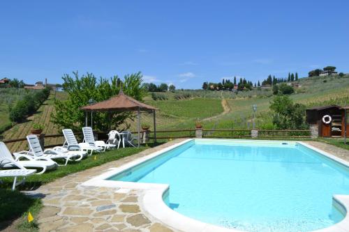 a swimming pool with chairs and a gazebo at Terre di Melazzano - Le Case di Patrizia in Greve in Chianti