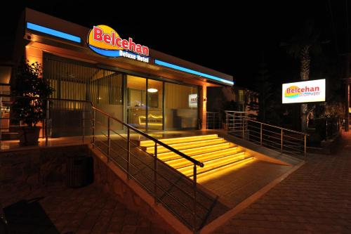 a restaurant with a neon sign in front of it at Belcehan Hotel in Oludeniz