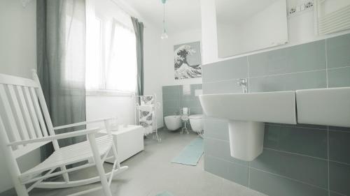 a white bathroom with a sink and a chair at BnB Anacleto in Bassacutena