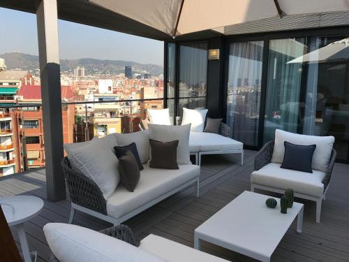 a balcony with couches and tables on a building at Cosmo Apartments Sants in Barcelona