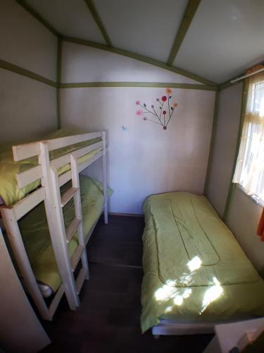 a small room with two bunk beds in it at Camping la Chicanette in Saint-Gilles