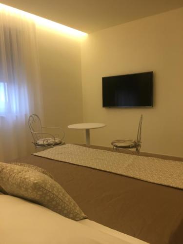 a room with a tv and a bed and a table at Hotel Victoria in Torre Santa Sabina