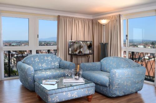 a living room with a blue sofa and a couch and a table at Ambasciatori Palace in Montecatini Terme