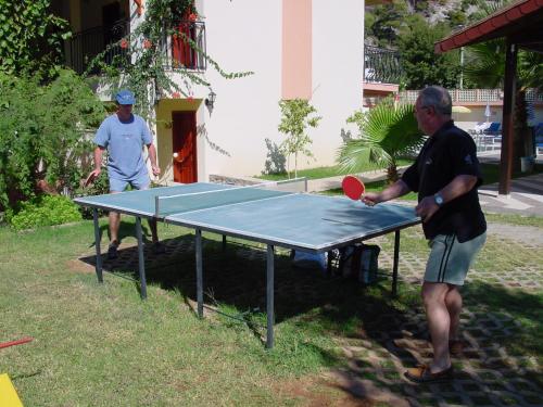 two men playing ping pong on a ping pong table at Belcehan Beach in Oludeniz